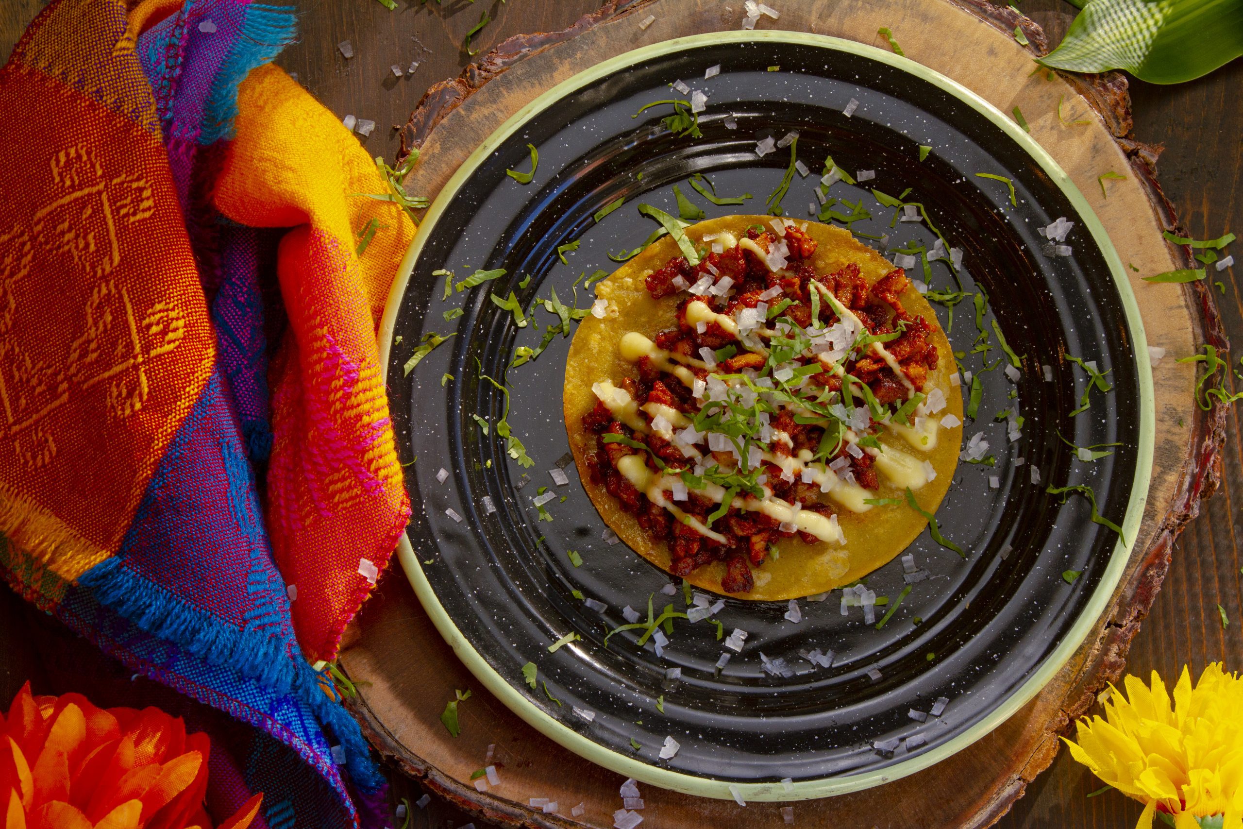 A single, delicious-looking taco on a dark blue plate.