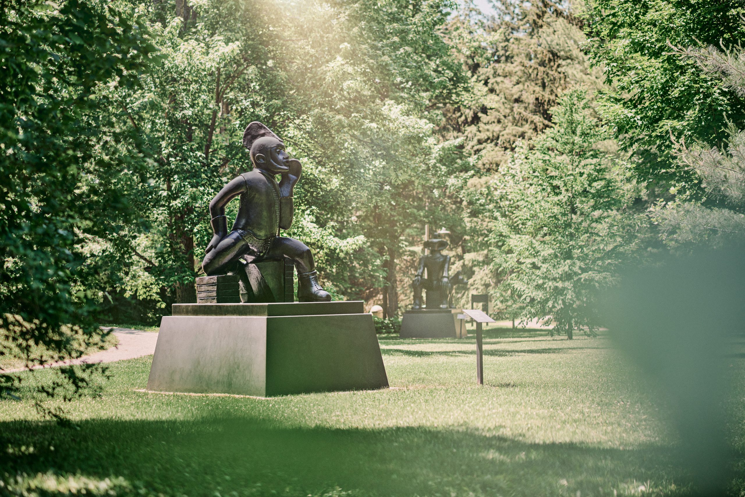 A statue in a park surrounded by trees