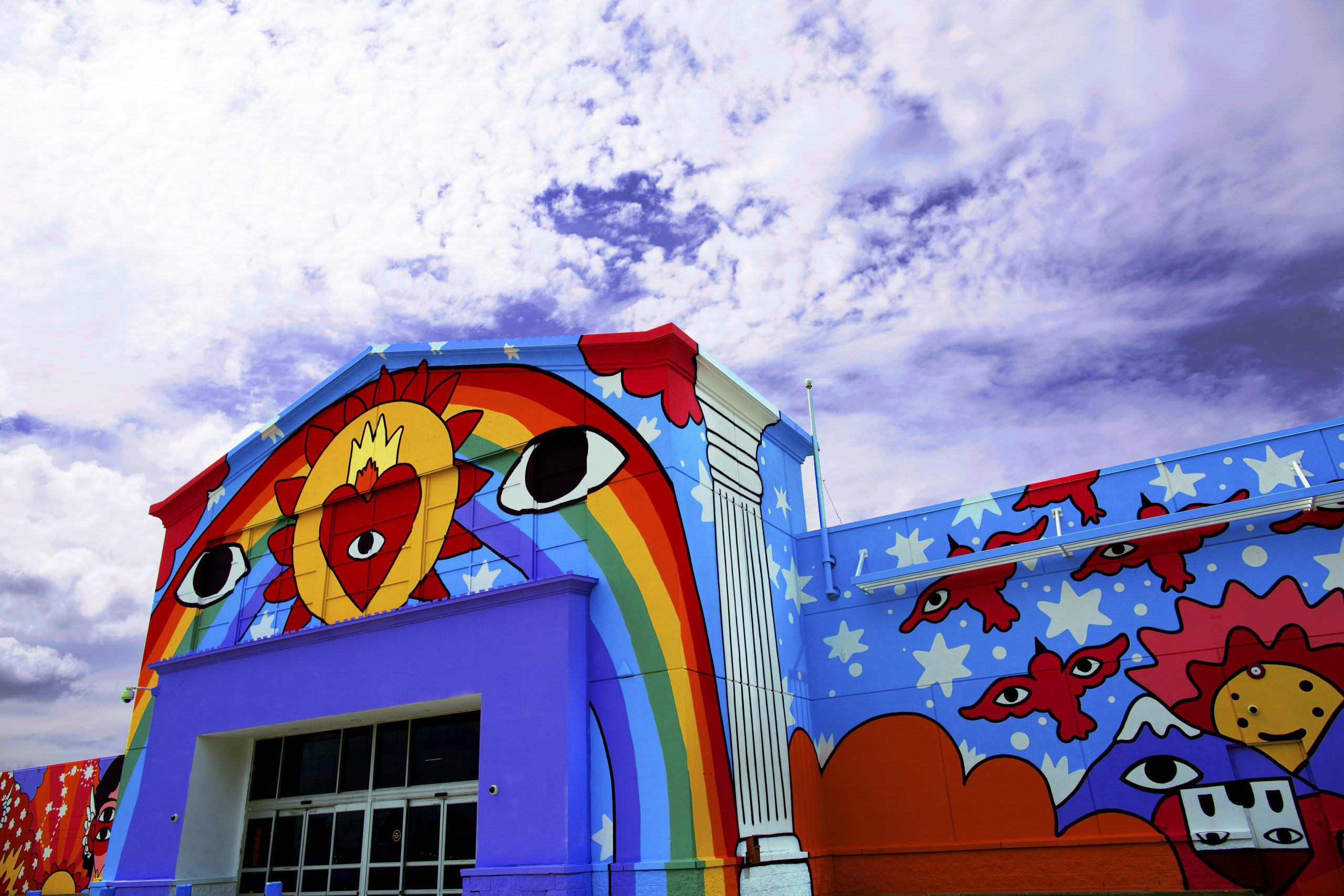 Building covered in colourful paint, showing a rainbow, eyes and heart.